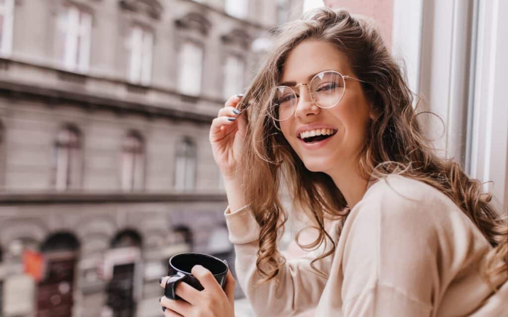 Dentista en Lindavista: la tendencia de las sonrisas auténticas que arrasa en redes sociales 1 “Mujer joven con lentes sonriendo de forma natural, ejemplo de tendencia dental auténtica en Lindavista”